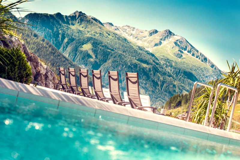 Sonnenliegen am Außenbecken der Felsentherme Gastein mit Panoramablick – Wellness mit Hund in den Alpen