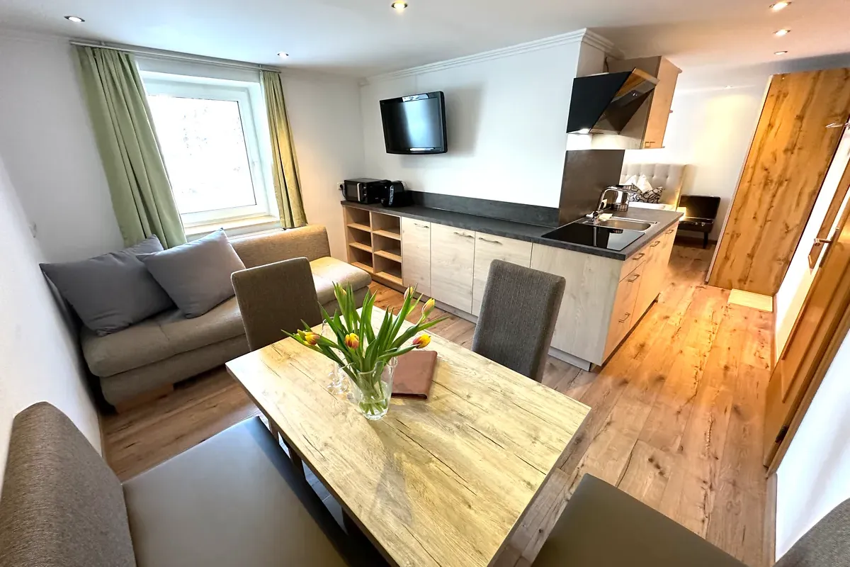 Apartment Kreuzkogel mit Essbereich und Wohnbereich rund um das Badezimmer bei GRUBERS Hotel-Apartments Gastein