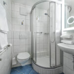 Detail im Badezimmer des Familienzimmers Bockhartsee mit Waschtisch und beleuchtetem Spiegel in Bad Gastein