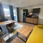 Wohnbereich im Familienzimmer Bockhartsee mit Küche Essbereich und Couch in Bad Gastein