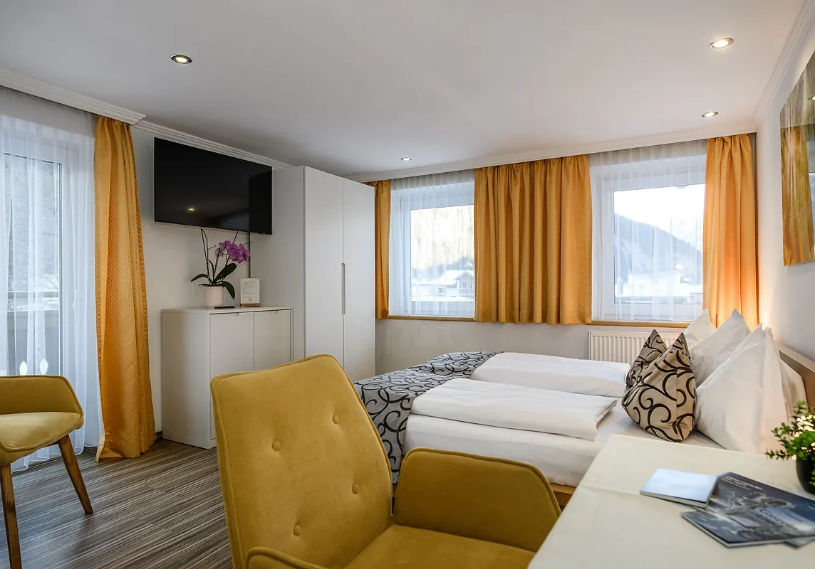Doppelbett und Sitzplatz im Doppelzimmer Palfnersee bei GRUBERS
