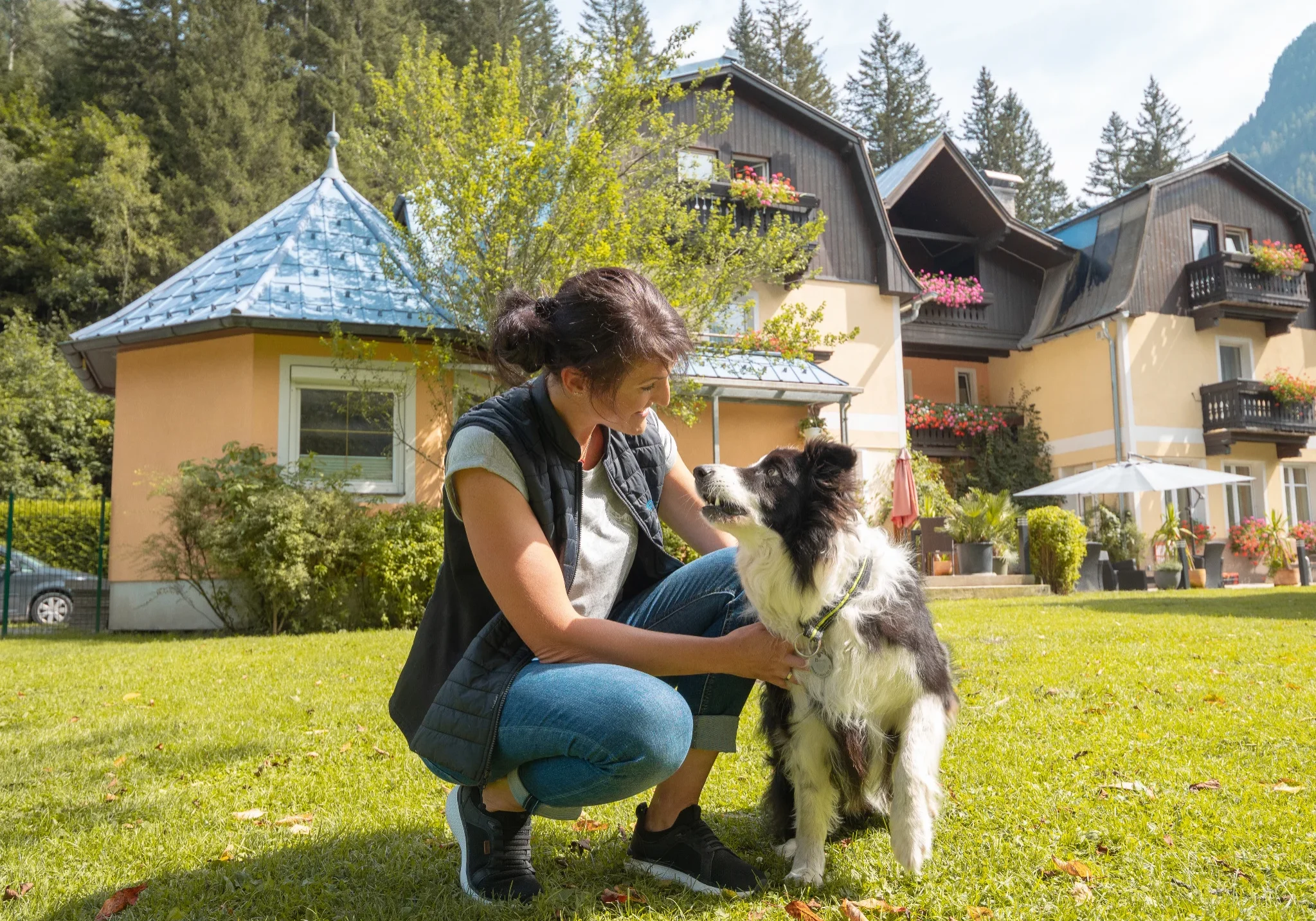 Hundetrainerin Conny Pfund beim Training mit Border Collie im Garten des GRUBERS Hotel-Apartments Gastein